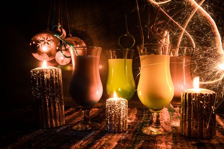 New Year and Christmas party concept. Different tasty cocktails with creative New Year holiday artwork decoration on background. Colorful cocktail in glass. Party club entertainment. Copy space.の写真素材
