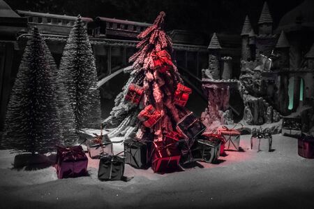 Miniature of winter snowy scene with train on bridge, medieval castle and lantern. Holiday attributes. Night scene. New Year and Christmas concept. Selective focusの写真素材