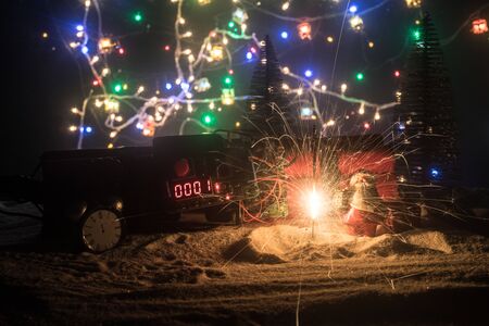 Christmas and New Year funny concept. Time bomb (dynamite) on snow with holiday decor and santa....
