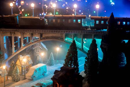 Miniature of winter snowy scene with train on bridge, medieval castle and small city. Holiday...