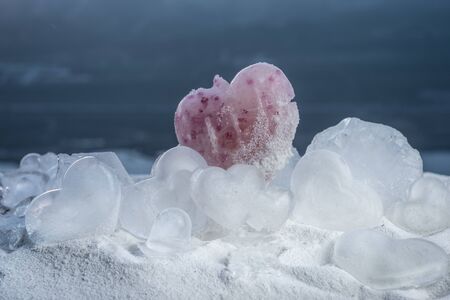 Beautiful ice heart figures on snow at sunset time. Winter holidays and love concept.の写真素材