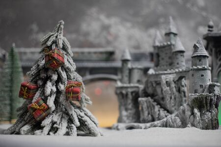 Miniature of winter snowy scene with train on bridge, medieval castle and lantern. Holiday attributes. Night scene. New Year and Christmas concept. Selective focusの写真素材