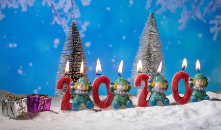 the numbers for the year 2020 stand in the snow with a pine branch decoration. Creative artwork holiday decoration. Empty space for your textの写真素材