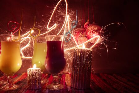 New Year and Christmas party concept. Different tasty cocktails with creative New Year holiday artwork decoration on background. Colorful cocktail in glass. Party club entertainment. Copy space.の写真素材