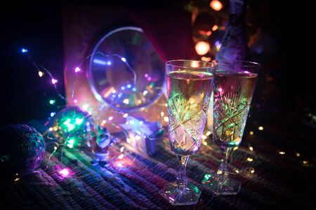 Two glasses of champagne with Christmas decoration. Traditional winter holiday alcohol drink in snow with creative New Year artwork. Copy space. Selective focusの写真素材