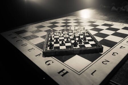Chess board game concept of business ideas and competition. Chess figures on a dark background with smoke and fog. Selective focusの写真素材