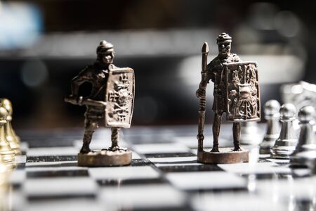 Medieval battle scene with cavalry and infantry on chessboard. Chess board game concept of business ideas and competition and strategy ideas Chess figures on a dark background with smoke and fog.の写真素材