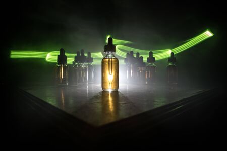 Vape concept. Smoke clouds and vape liquid bottles on dark background. Light effects. Useful as...