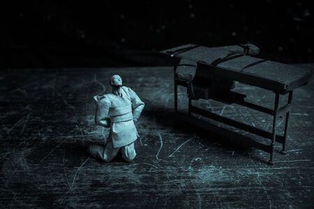 Lethal injection concept. Prisoner handcuffed to death by lethal injection. Creative artwork decoration with scale model on dark with lights.の写真素材