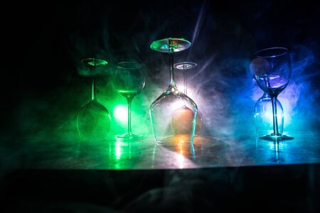 Goblet of wine on wooden table with beautiful toned lights on background. Glasses of wine on dark...