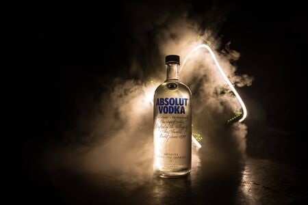 BAKU, AZERBAIJAN - FEB 09, 2020: Absolut Vodka is a brand of vodka, produced near Ahus, in Sweden. Owned by French group Pernod Ricard. Bottle of vodka on wooden table with dark toned foggy background.のeditorial素材