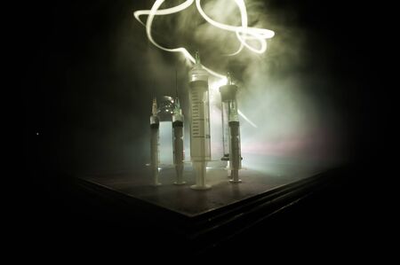 Health medical concept. Medical syringes on wooden table with toned foggy background. Creative...