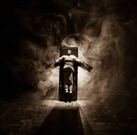 Lethal injection concept. Prisoner handcuffed to death by lethal injection. Creative artwork decoration with scale model on dark with lights.の写真素材