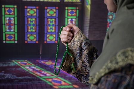 Muslim woman praying for Allah muslim god at the mosque. Hands of muslim woman on the carpet praying in traditional wearing clothes, Woman in Hijab.の写真素材