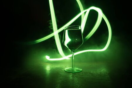 Goblet of wine on wooden table with beautiful toned lights on background. Glasses of wine on dark...