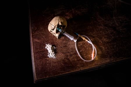 Narcotic drug problem concept. Drug syringe and narcotic attributes on wooden table. Purchase, possession and sale of drugs is punishable by law. Creative artwork decorationの写真素材