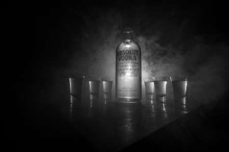 BAKU, AZERBAIJAN - FEB 09, 2020: Absolut Vodka is a brand of vodka, produced near Ahus, in Sweden. Owned by French group Pernod Ricard. Bottle of vodka on wooden table with dark toned foggy background.のeditorial素材