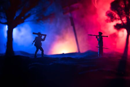 Military soldiers silhouettes with bazooka and rpg. War Concept. Military silhouettes fighting scene on war fog sky background, Mojahed with rpg and us soldier with bazooka at sunset. Attack sceneの写真素材