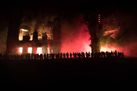 Creative artwork decoration. Crowd looking on burning city destroyed by war. Selective focusの写真素材