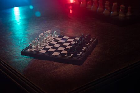 Chess board game concept of business ideas and competition. Chess figures on a dark background with smoke and fog. Selective focusの写真素材