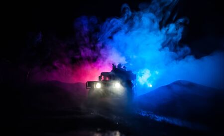 War Concept. Battle scene on war fog sky background, Fighting silhouettes Below Cloudy Skyline at night. Army vehicle with soldiers artwork decoration. Selective focusの写真素材