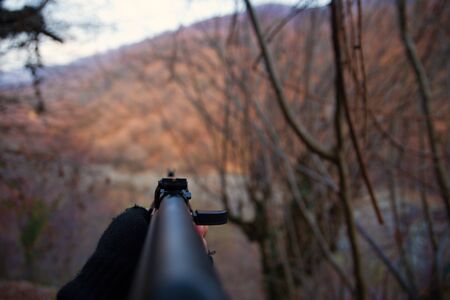 Shooter aiming target with assault rifle weapon. Dangerous bandit aiming gun. Special soldier during...
