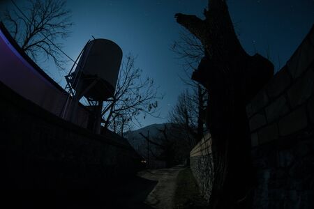Full moon over quiet village at night. Beautiful night landscape of mountain village under the moonlight. Azerbaijan nature. Long exposure shotの写真素材