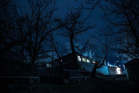 Full moon over quiet village at night. Beautiful night landscape of mountain village under the moonlight. Azerbaijan nature. Long exposure shotの写真素材