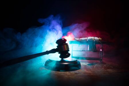 Lethal injection concept. Prisoner handcuffed to death by lethal injection. Creative artwork decoration with scale model on dark with lights.の写真素材