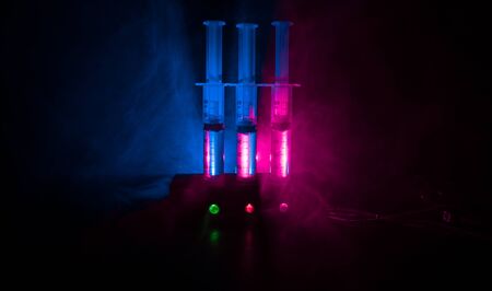 Lethal injection concept. Prisoner handcuffed to death by lethal injection. Creative artwork decoration with scale model on dark with lights.の写真素材