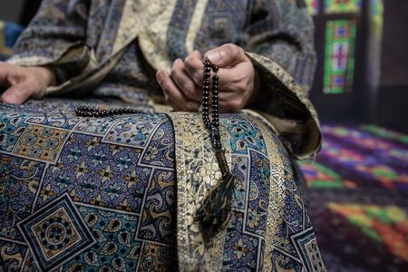 Muslim woman praying for Allah muslim god at the mosque. Hands of muslim woman on the carpet praying...