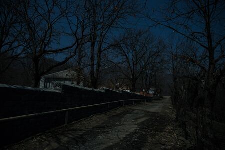 Full moon over quiet village at night. Beautiful night landscape of mountain village under the...