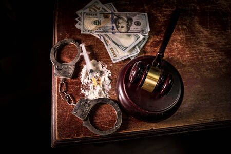 Narcotic drug problem concept. Drug syringe and narcotic attributes on wooden table. Purchase, possession and sale of drugs is punishable by law. Creative artwork decorationの写真素材
