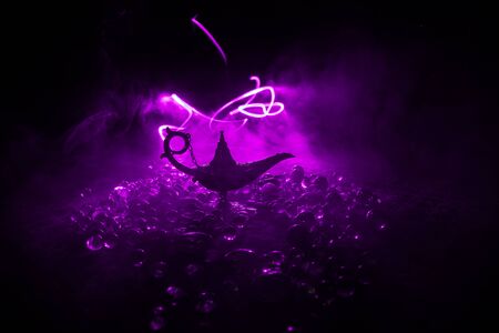 Antique Aladdin arabian nights genie style oil lamp with soft light white smoke, Dark background. Lamp of wishes conceptの写真素材