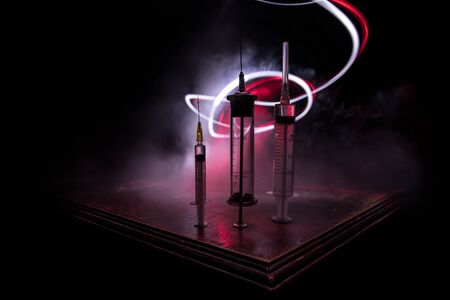 Health medical concept. Medical syringes on wooden table with toned foggy background. Creative...