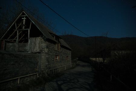 Full moon over quiet village at night. Beautiful night landscape of mountain village under the moonlight. Azerbaijan nature. Long exposure shotの写真素材