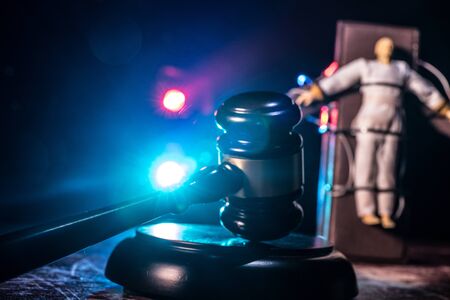 Lethal injection concept. Prisoner handcuffed to death by lethal injection. Creative artwork decoration with scale model on dark with lights.の写真素材