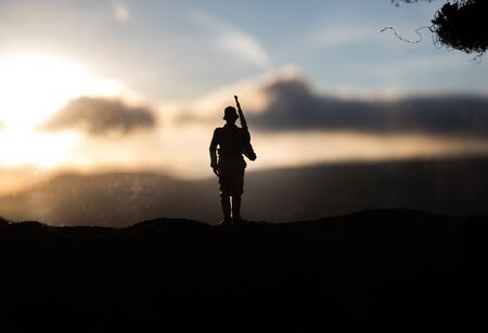 War Concept. Military silhouettes fighting scene on war fog sky background, World War Soldiers Silhouette Below Cloudy Skyline sunset. Selective focusの写真素材