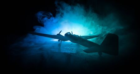 German Junker (Ju-88) night bomber at night. Artwork decoration with scale model of jet-propelled plane in possession. Toned foggy background with light. War scene. Selective focusの写真素材