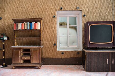 A realistic dollhouse living room with furniture and window at night. Artwork table decoration with handmade realistic dollhouse. Selective focus.の写真素材
