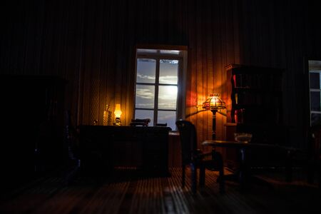 A realistic dollhouse living room with furniture and window at night. Artwork table decoration with handmade realistic dollhouse. Selective focus.の写真素材