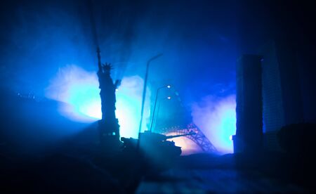 Empty street of burnt up city, flames on the ground and blasts with smoke in the distance. Apocalyptic view of city downtown as disaster film poster concept. Night scene. City destroyed by war.の写真素材