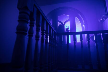 Inside of old creepy abandoned mansion. Silhouette of horror ghost standing on castle stairs to the basement. Horror Halloween conceptの写真素材