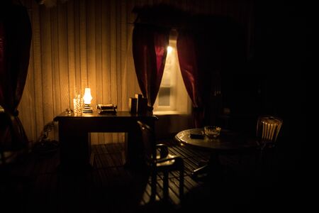 A realistic dollhouse living room with furniture and window at night. Artwork table decoration with handmade realistic dollhouse. Selective focus.の写真素材