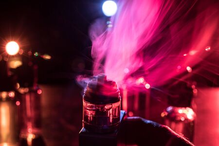 Vape concept. Electronic Cigarette vape explosion. Smoke clouds and vape liquid bottles on dark...