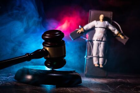 Lethal injection concept. Prisoner handcuffed to death by lethal injection. Creative artwork decoration with scale model on dark with lights.の写真素材