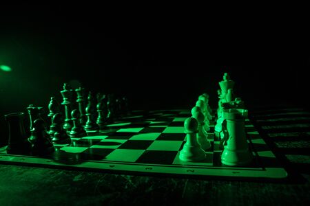 Chess board game concept of business ideas and competition. Chess figures on a dark background with smoke and fog. Selective focusの写真素材