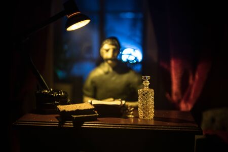 A realistic dollhouse living room with furniture and window at night. Man sitting on table in dark...