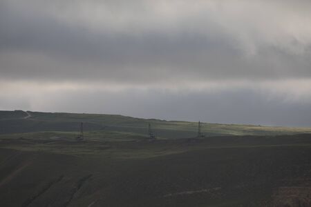 Ancient traditional classical oil pumps at the mountains in sunny weather. Baku, Azerbaijan