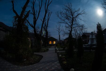 Full moon over quiet village at night. Beautiful night landscape of mountain village under the moonlight. Azerbaijan nature. Long exposure shotの写真素材